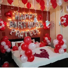To make birthdays more personal, I can hang photos from the balloons, as seen here. This setup combines red and white balloons with fairy lights and a custom name for a heartfelt celebration.