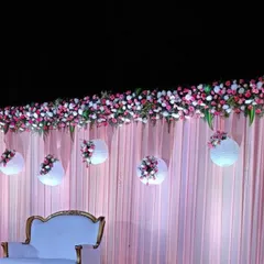 This engagement stage for a night ceremony features a soft pink draped backdrop. I added a thick border of pink and white flowers on top and hung decorated paper lanterns for a delicate and romantic touch.
