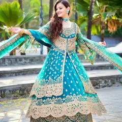 A joyful, dynamic shot of a model in a beautiful blue and gold Anarkali gown. Capturing movement like this brings the outfit to life, making it ideal for lookbooks.