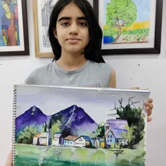 A young artist shows her completed watercolor landscape, featuring purple mountains and a reflective lake. This piece highlights her progress in creating atmospheric depth.