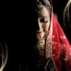An artistic close-up of a bride, with half her face in shadow. This technique highlights her delicate features, jewelry, and the serene emotion of the moment.