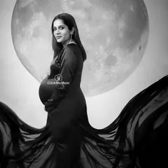 A classic black and white portrait with my signature moon backdrop. The monochrome tones add a sense of drama and timelessness, focusing on the elegant silhouette of the mother-to-be.