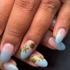 Getting ready for a beach vacation with this ocean-themed set. It features a glittery blue ombre and cute 3D gold seashell and starfish charms.