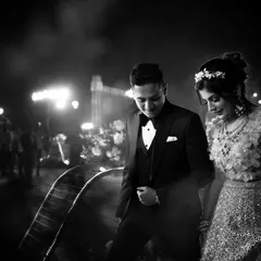 A candid black and white photo of the couple making their entrance at the reception. The focus is on their shared moment as they step into the celebration together.