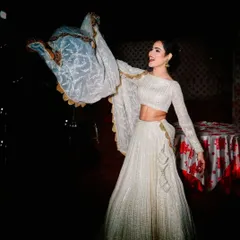 The joy of wearing a beautiful outfit. This photo captures the movement of the white Chikankari lehenga, showing off the flow of the skirt and the delicate dupatta.