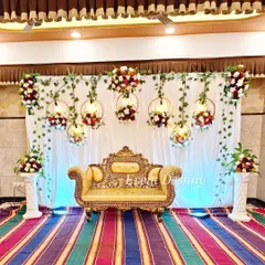 A similar stage design with hanging floral hoops, but set against a colorful striped carpet, which adds a unique and vibrant touch to the overall look.