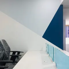 The completed office space, showing the geometric color-blocked wall design. This simple but effective feature adds a strong graphic element to the workspace.