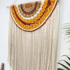 This half-moon macrame hanging brings such warm, earthy vibes to a space. The design features layers of mustard, maroon, and brown tones with detailed knotting and wooden beads, creating a beautiful semi-circular pattern.
