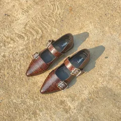 My new bestseller, the buckled ballet flat in a rich, brown croc-embossed leather. The texture of the leather combined with the silver hardware creates a shoe that feels both luxurious and modern.