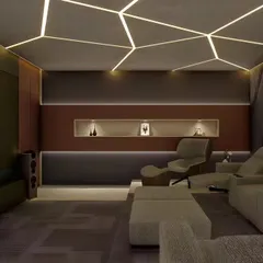 A modern home theater with geometric LED lighting on the ceiling. The room features a mix of lounge chairs and sofas, providing a comfortable and stylish space for watching movies.