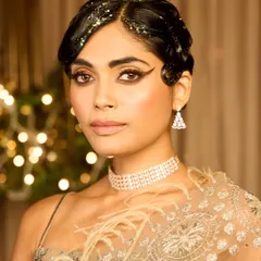 I love diving into vintage looks, and this Gatsby-inspired style was for a special cocktail party theme. I created classic 1920s finger waves with a modern twist of hair glitter, paired with a dramatic winged eyeliner and glowing skin to capture the opulence of the era.