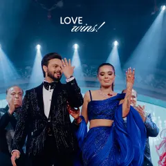 "Love wins!" The couple takes a bow on stage after a fantastic performance, surrounded by applause and bright lights. A perfect end to a memorable act.