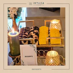 A simple yet elegant dessert offering of marble and lemon tea cakes. They are presented on a golden tiered stand, surrounded by the warm glow of candles, making for a very inviting display.