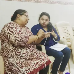 Focusing on the details is key. In this photo, I am showing a student the correct way to hold the crochet hook and manage yarn tension, two fundamental skills for creating neat and even stitches.