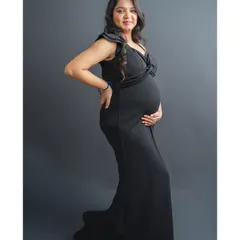Every mother is a queen, and this portrait is designed to celebrate that. Here, the mom-to-be wears a stunning black maternity gown and a delicate crown, creating a timeless and empowering solo portrait against a classic studio backdrop.