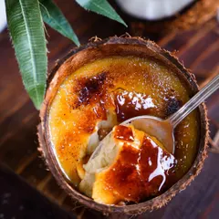 Our exquisite Crème Caramel served in a natural coconut shell. This dessert combines silky custard with a rich caramel top, offering a classic taste with a tropical, innovative presentation.