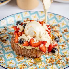 An action shot like this is pure gold for social media and menus. Capturing the perfect pour creates a dynamic, mouth watering image that makes customers feel the texture and richness of the dish before they even order.