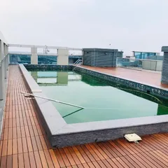 This rooftop installation showcases the beauty and functionality of IPE wood decking surrounding a pool. The wood's natural oils make it weather resistant, perfect for exposed urban environments.