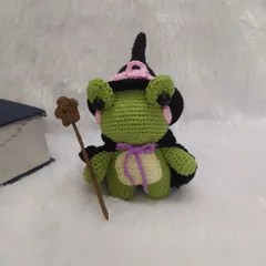 Another look at the wizard frog next to his spellbook. The details, like the purple bow and the star on his wand, are what make each toy special.