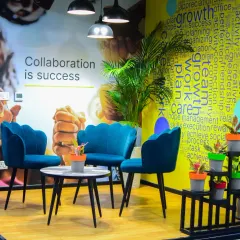 We created this cozy breakout area to show how plants can make collaborative spaces more inviting. The combination of a large Areca Palm and smaller potted plants on tiered stands adds texture and life, turning a simple seating arrangement into a refreshing retreat.