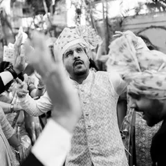 A black and white shot from the baraat that focuses on the groom's friend dancing with full energy. Monochrome can really amplify the emotion and action in a chaotic scene.