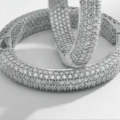 This macro photograph captures the intricate detail of pavé-set diamond hoop earrings. Every single diamond is in sharp focus, demonstrating the precision required for high-end e-commerce imagery where texture and quality are paramount.
