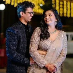 A candid moment of laughter and love between the couple at their evening reception, with beautiful bokeh lights in the background.