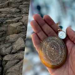 A collage of textures and time. The rough, rocky terrain of a hill is juxtaposed with a smooth, intricately carved antique pendant held in my hand.