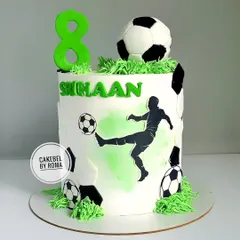 A clean and modern football cake for Srihaan's 8th birthday. The design features a silhouette of a player in action, a 3D fondant soccer ball, and edible grass.
