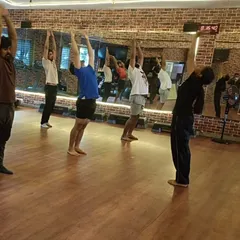 A side view of the group holding the upward salute, demonstrating the collective energy and focus in our yoga classes.