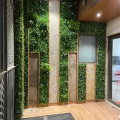A balcony wall in Faridabad is given a major upgrade with this design. Panels of artificial vertical gardens are framed by stone-look tiles and wood, creating a sophisticated and low-maintenance feature wall.