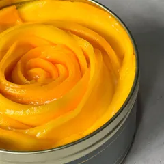 A close-up of the fresh, juicy mango that crowns our seasonal Tres Leches cake. We believe in using only the best ingredients.