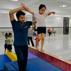 Every step on the beam is a lesson in focus and trust. Here, I am personally guiding one of our young gymnasts, ensuring she feels safe and supported as she builds her balance and coordination. This hands-on approach is at the heart of our coaching.