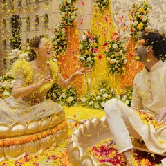 The pure joy of a Haldi ceremony, where the couple shares a playful moment amidst a shower of marigold petals in custom lotus-themed seating. I focus on creating vibrant, fun-filled pre-wedding events that are full of laughter.