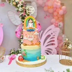 A fun and colorful custom cake for a party, featuring a rainbow and other playful elements.