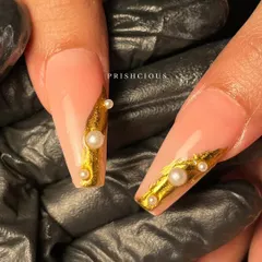 A close-up on the delicate pearl details accenting the gold chrome on these long coffin nails. It's all about the little things that make a set feel luxurious.