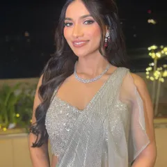 A beautiful smiling shot of the bride, her soft waves cascading over her shoulders, perfectly complementing her shimmery silver saree.