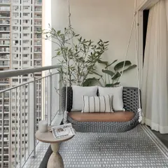 This serene balcony is a personal oasis amidst the vibrant Mumbai cityscape. The elegant cement-finish floor, with its calming shades of grey and white, sets the stage for a tranquil retreat.