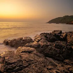 A vertical composition of a rocky sunset, where the warm light on the horizon contrasts with the cool tones of the sky.