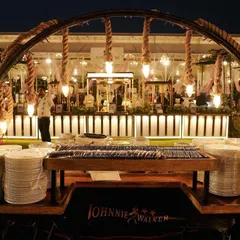 This rustic and industrial-chic setup features rope details and Edison bulbs, perfectly complementing the outdoor venue. We ensure every element, from the plate stacks to the lighting, aligns with the event's aesthetic.