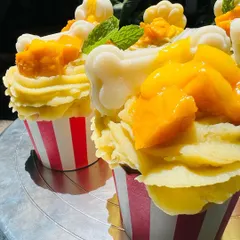 A close-up of the Mango Tango pupcakes, showing the creamy frosting and the handmade jelly bone decoration.
