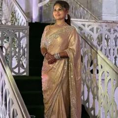A client looking absolutely regal in a golden saree, perfect for a reception or grand evening event. The makeup is classic and elegant, with defined eyes and a warm glow.