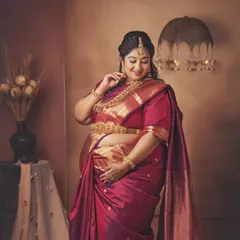 A portrait of a queen awaiting her heir. The rich texture of the silk saree and the intricate gold jewelry create a look of pure royalty and grace for this mom-to-be.