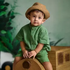 A sweet and classic portrait from an indoor session. The combination of a simple outfit, a cute hat, and a themed backdrop creates a timeless look.