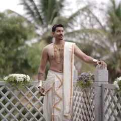 Another angle showcasing the groom's attire. The gold-finish necklace and arm cuff add a touch of royalty.