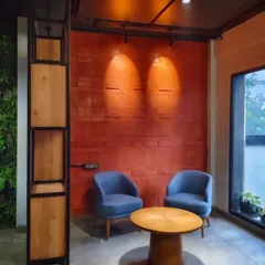 We believe every office needs a comfortable escape. This cozy breakout corner, with its warm accent lighting and comfortable seating against a textured brick wall, provides a quiet space for informal chats or focused individual work.