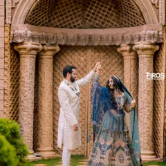 A dance of love in front of a grand, ornate doorway. The couple's elegant lehenga and sherwani are perfectly complemented by the regal architecture.