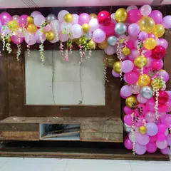 We can decorate any part of your home, including entertainment units. This L-shaped balloon garland with hanging floral accents adds a splash of color and festivity to the living room.