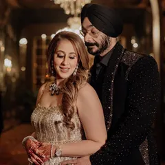 A power couple moment. The groom wears a custom black tuxedo jacket, subtly embellished with shimmering sequins on the shoulders and lapels, creating a look of sophisticated glamour for their special night.