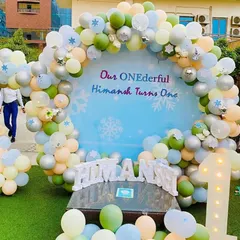 I can transform any outdoor space for a beautiful celebration, like this "ONEderful" first birthday party. This setup features a large themed backdrop, a custom balloon arch in pastel colors, and light-up marquee numbers that look great day or night.